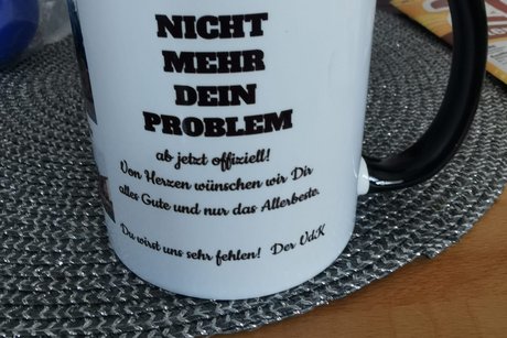 Bild zeigt eine Tasse (Vorderseite) mit der Aufschrift ""NICHT MEHR DEIN PROBLEM - ab jetzt offiziell! - Von Herzen w&uuml;nschen wir Dir alles Gute und nur das Allerbeste - Du wirst uns sehr fehlen! Der VdK"