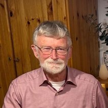 Ein Mann im Rentenalter mit grauen Haaren, Brille und Vollbart