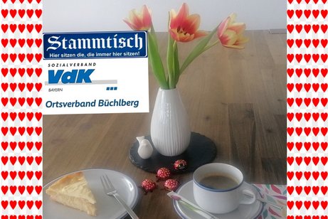 Zu sehen ist ein Holztisch mit Kaffee und Kuchen eingerahmt mit Herzen