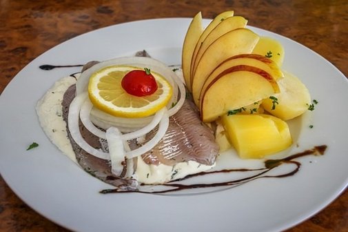 Teller mit eingemachten Heringen , Kartoffeln, &Auml;pfeln und Zwiebeln