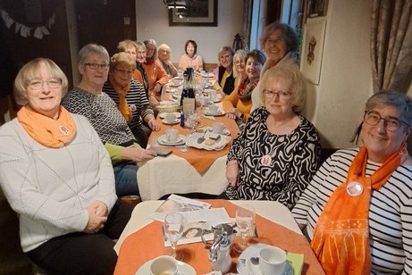 Informationsveranstaltung anlässlich "Orange Day" am 25.11.20225 Frauen sitzen zusammen am Tisch - alle tragen aus Solidarität ein orangefarbenes Kleidungsstück