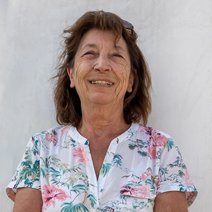 Johanna Moll, kommissarische stellvertretende Vorsitzende und kommissarische Kassiererin des VdK Ortsverbands Aubing, steht vor einem hellen Hintergrund und lächelt freundlich in die Kamera. Sie trägt eine helle Bluse mit floralem Muster und eine hellblaue Hose. Ihre Arme sind locker vor dem Körper verschränkt, und ihre Sonnenbrille ist auf dem Kopf aufgesetzt.