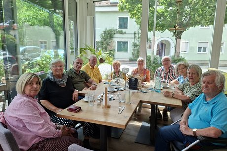 Unsere derzeitige Stammtischrunde 10 Personen sitzen im Halbkreis im Wintergarten des Cafe Stärkls