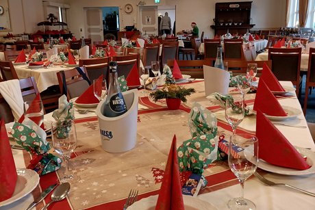 festlich gedeckte Tische mit kleinen Pr&auml;senten