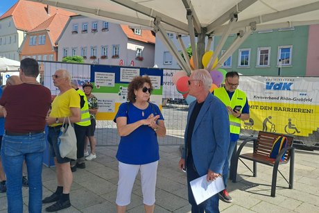 Menschen im Gespräch am Infostand
