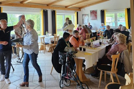 2 Paare tanzen, an 3 Tischen sitzen G&auml;ste und schauen zu