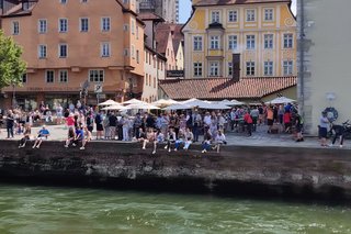 Ufermauer mit vielen Menschen sitzend auf der Kaimauer