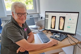 Abgebildet ist ein Mitarbeiter der Firma Hudetz beim Fuss-Scan