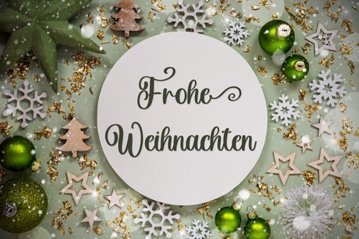 Weihnachtswunsch mit Sternen und Kugeln im Hintergrund Grafik mit weihnachtlicher Deko und dem Text „Frohe Weihnachten“.