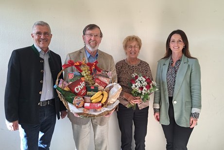 vier Personen in der Mitte die Ausscheidenden mit Blumen und Geschenkkorb