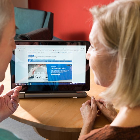 Ein &auml;lteres Paar am Computer, auf dem Bildschirm sieht man die Facebook-Seite des VdK Deutschland