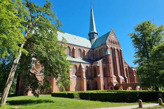 Abgebildet ist eine Backsteinkirche in Bad Doberan