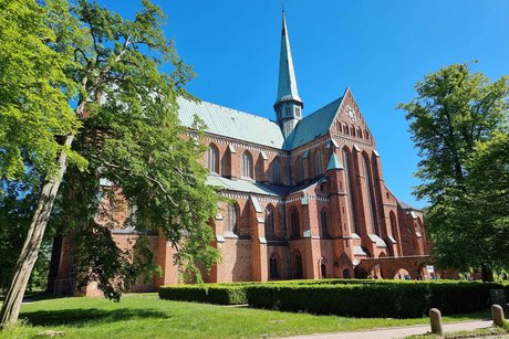 Abgebildet ist eine Backsteinkirche in Bad Doberan