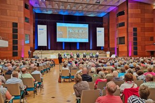 Abgebildet sind die vielen Teilnehmer mit Blick auf die Bühne