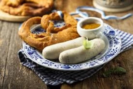 Man sieht auf dem Bild ein Paar Weißwürst mit Senf und Breze