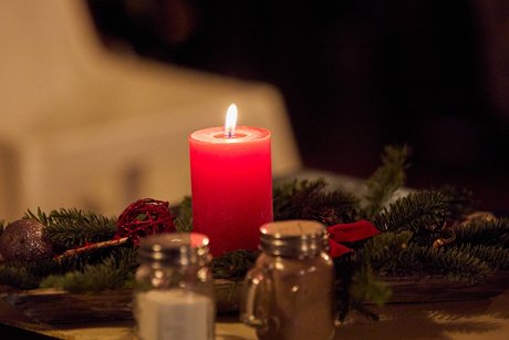 Weihnachtsdeko auf den Tischen, grüne zweige mit roter Kerze