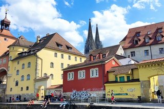 Stadtkulisse von Regensburg vom Boot aus gesehen, links im Hintergrund ein Teil der Steinernen Brücke