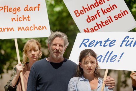 Gruppe von Menschen verschiedenen Geschlechts und Alters, mit und ohne Behinderung, demonstrieren. Auf den Demopappen steht "Pflege darf nicht arm machen", "Behinderung darf kein Nachteil sein" und "Rente f&uuml;r alle"