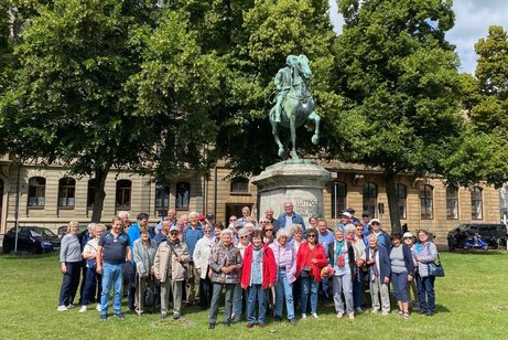 Gruppe mit Frauen und M&auml;nner vor einer Reiter-Statue mit Prinz Luitpold von Bayern