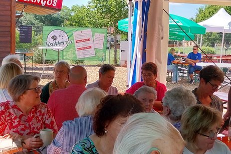 Gäste sitzen beim Kaffeekränzchen im Festzelt