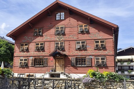 Das Bild zeigt einen alten Gasthof in Schwarzenberg, der au&szlig;en in dunklem Rot gestrichen ist.
