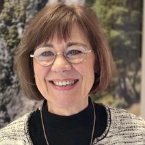 Marianne Humplmair l&auml;chelnd vor B&auml;umen