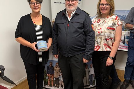 Susann Enders mit goldener Klopapierrolle, ein Mann und Jana Krämer, Kreisgeschäftsführerin VdK Oberland