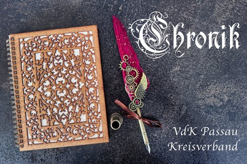 Chronik des Kreisverbandes Passau Zu sehen ist ein Buch mit verziertem Einband und einer kostbaren Kalligraphie Schreibfeder