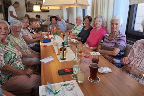 Menschen sitzen an Tisch in Gasthaus