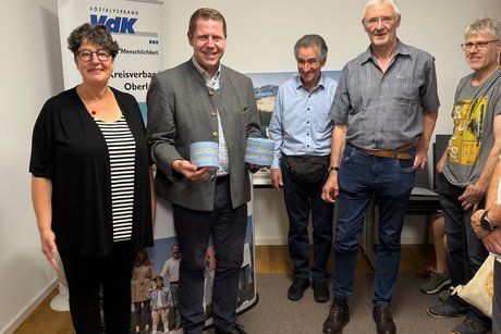 Daniel Schimmer mit goldenen Klopapierrollen neben Susann Enders und anderen Menschen