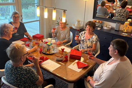 Mit Freude bei der Sache 6 Frauen sitzen am Tisch und basteln und trinken dabei Prosecco.
