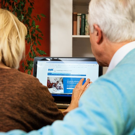 Ein &auml;lteres Paar am Computer, auf dem Bildschirm sieht man die Facebook-Seite des VdK Deutschland