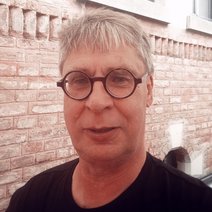 Vorstand-Beisitzer Thomas Görner mit Brille vor roter Ziegelwand