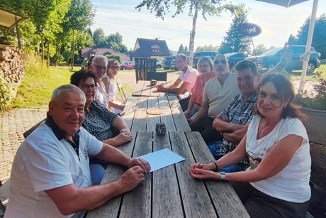 Eine Gruppe von Persohnen am Tisch sitzend