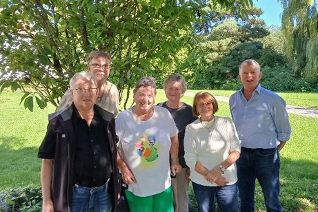6 Personen im Freien vor einem Baum stehend fotografiert
