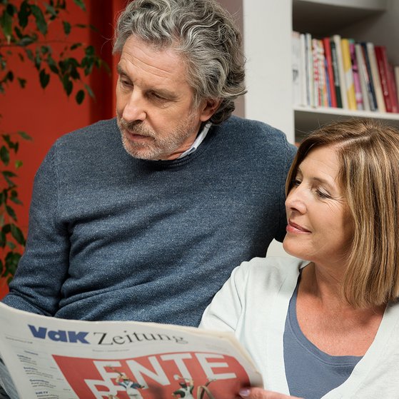 Paar liest die VdK-Zeitung Ein Mann und eine Frau schauen gemeinsam in die VdK-Zeitung, auf der Titelseite geht es um das Thema Rente