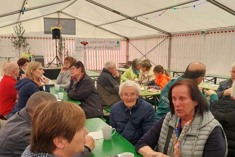 Gäste sitzen im Bierzelt an Tischen zum Kaffeeplausch