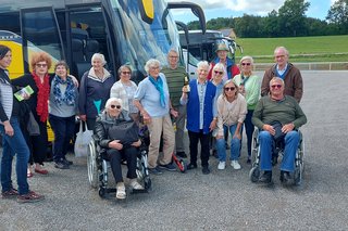 Das Bild zeigt eine Gruppe von Senioren vor dem Bus.