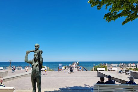 Eine Statue bei blauem Himmel vor dem Strand