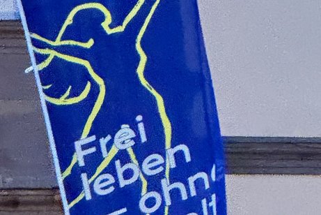 blaue Fahne mit der Aufschrift Frei leben ohne Gewalt