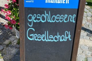 Aufsteller am Eingang zum Angerbauerhof mit Text "Geschlossene Gesellschaft"