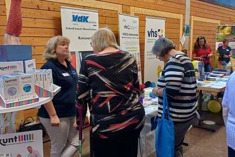 Die Kreisgeschäftsführerin steht am Infostand und spricht mit Besuchern