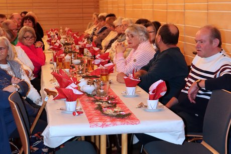 Menschen sitzen an sch&ouml;n gedeckten Tischen