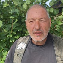 Ein Mann mittleren Alters mit kurzen grauen Haaren und einem Dreitagebart