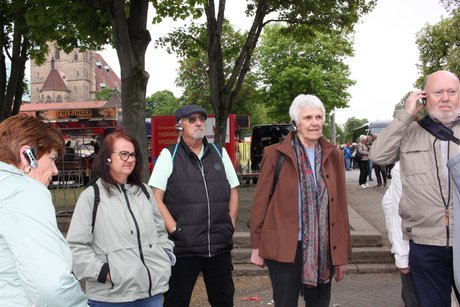 F&uuml;nf Mitglieder h&ouml;ren mit den Ohrh&ouml;rern Erkl&auml;rungen zur Stadt.