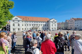 Abgebildet sind die Reiseteilnehmer vor dem Rathaus Wismar