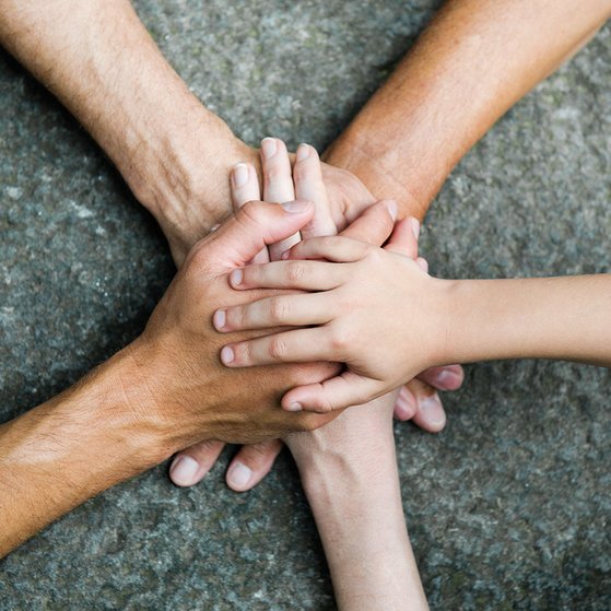 F&uuml;nf Personen legen jeweils eine Hand aufeinander, so dass ein Kreis bzw. ein Stern entsteht