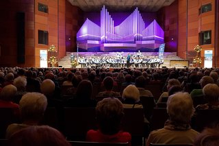 viele Menschen in einem großen Saal mit Musikern auf der Bühne