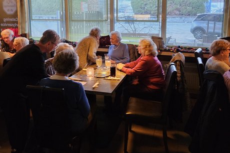 einige Frauen sitzen an Tischen und unterhalten sich