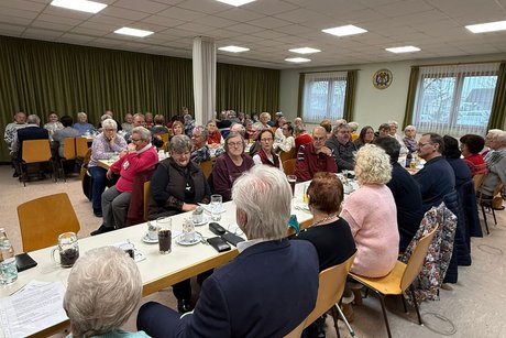 Eine Gruppe &auml;lterer Menschen sitz an verschiedenen Tischen